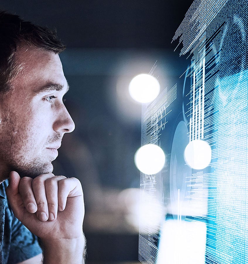 young man reading in front of a screen