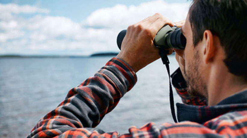 Man with binoculars as a symbol for forecasts.